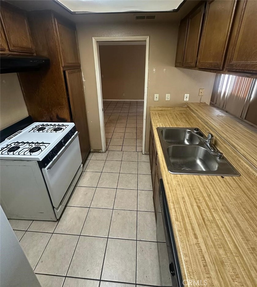 155 South Wilmington Avenue, Unit C Compton, CA 90220 - Photo 19 of 26 a kitchen with a sink a stove and refrigerator