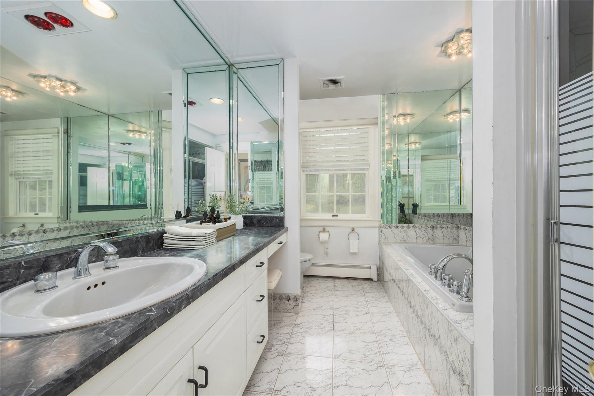 219 Maple Avenue Monroe, NY 10950 - Photo 18 of 40 a bathroom with a granite countertop tub sink a mirror and a shower