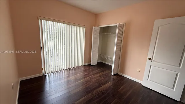 an empty room with wooden floor and a window