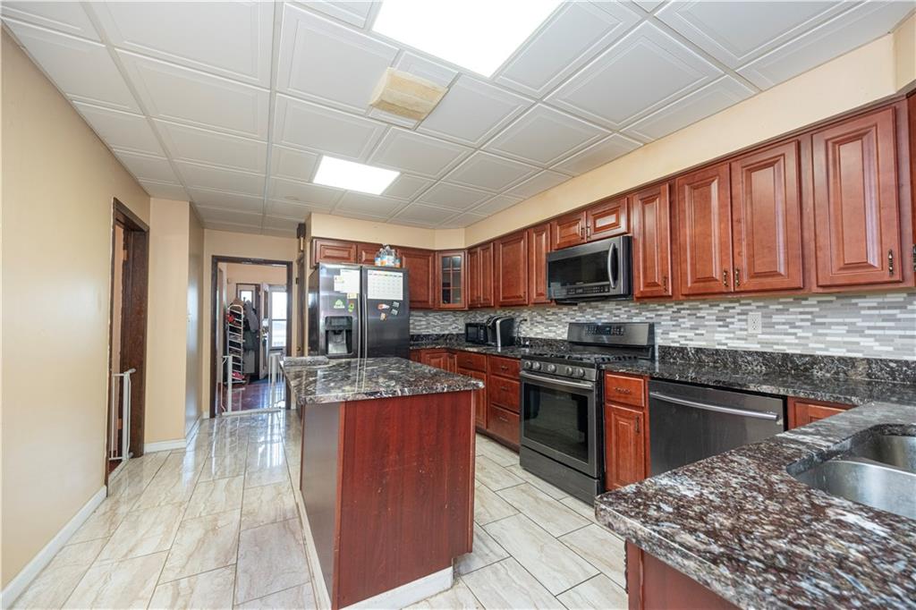 33 5th Street Pittsburgh, PA 15215 - Photo 11 of 43 a kitchen with stainless steel appliances granite countertop a stove top oven a sink dishwasher a dining table and chairs with wooden floor