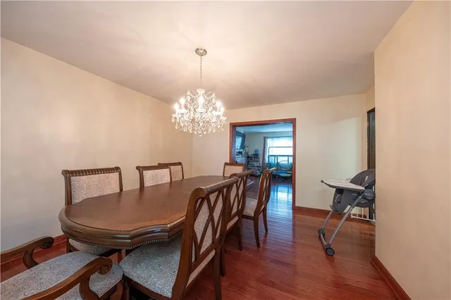 a kitchen with stainless steel appliances granite countertop a stove top oven a sink dishwasher a dining table and chairs with wooden floor