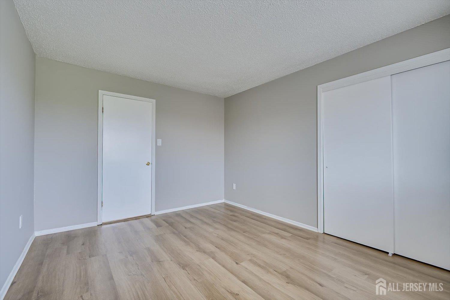 1607 Edison Glen Terrace Edison, NJ 08837 - Photo 16 of 19 a view of an empty room with wooden floor