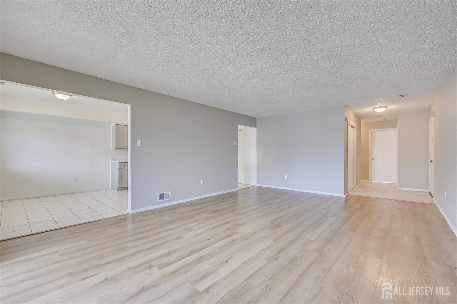 1607 Edison Glen Terrace Edison, NJ 08837 - Photo 3 of 19 a view of an empty room with wooden floor and a window