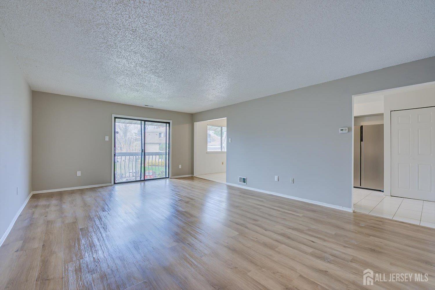 1607 Edison Glen Terrace Edison, NJ 08837 - Photo 4 of 19 a view of an empty room with window and wooden floor