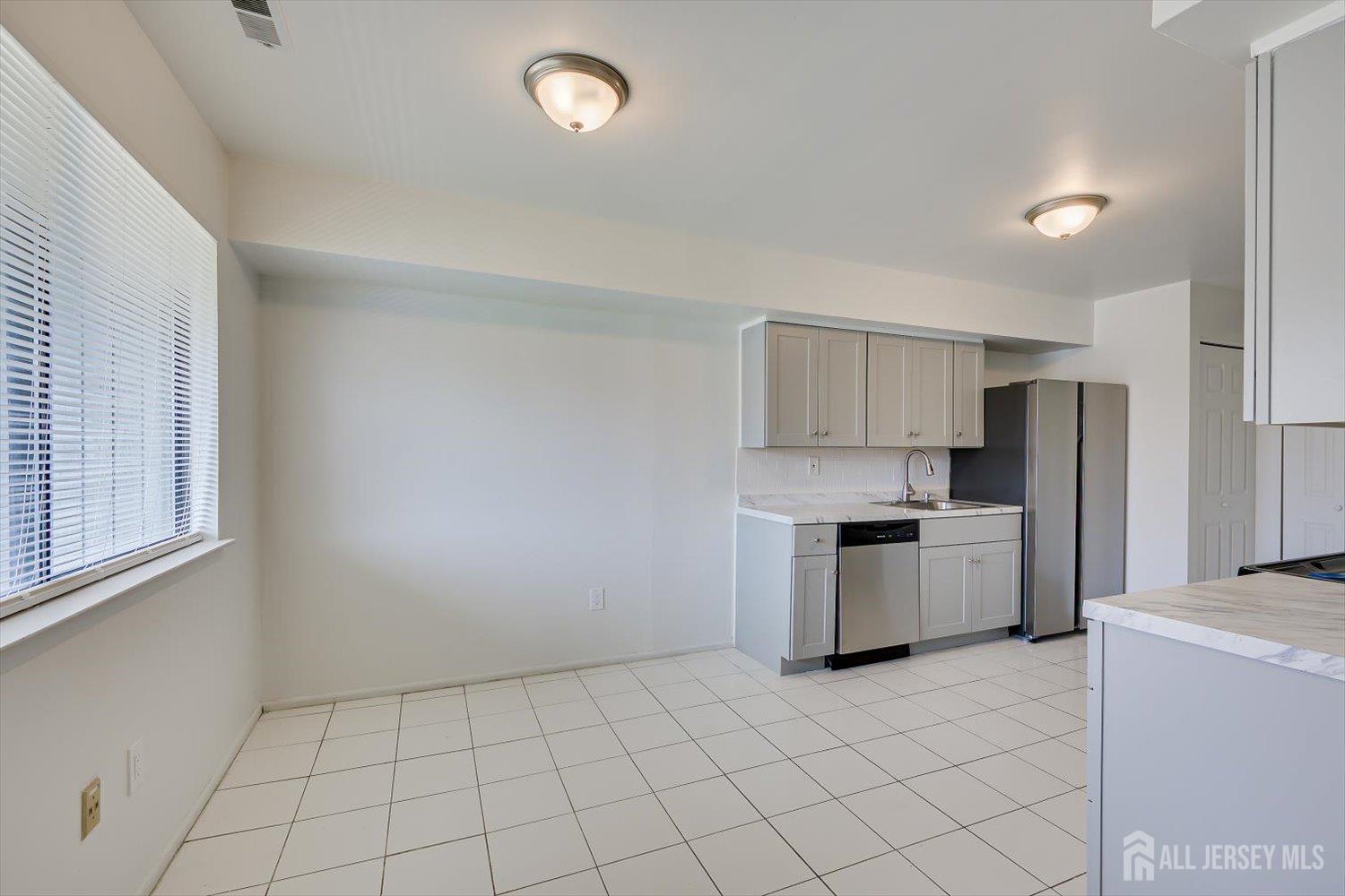 1607 Edison Glen Terrace Edison, NJ 08837 - Photo 7 of 19 a kitchen with a refrigerator a stove top oven and cabinets