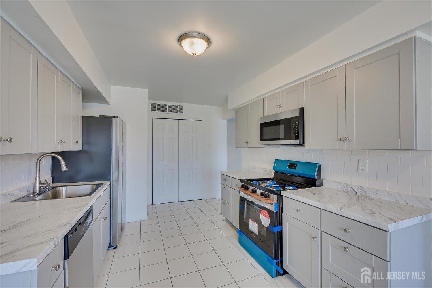 1607 Edison Glen Terrace Edison, NJ 08837 - Photo 8 of 19 a kitchen with stainless steel appliances granite countertop a sink stove top oven and cabinets