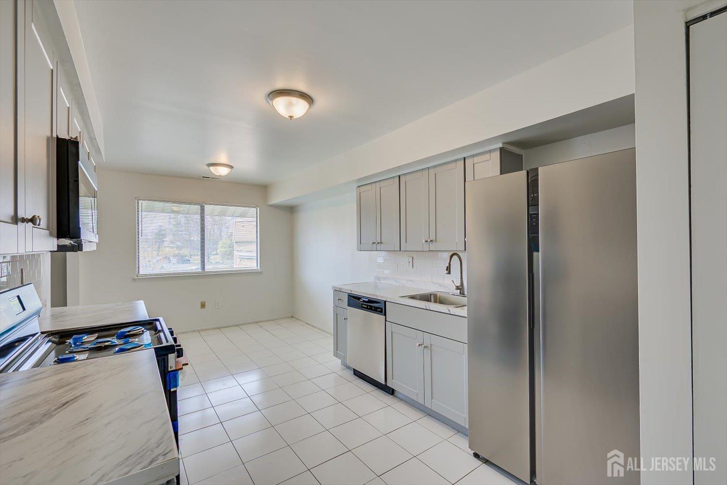 1607 Edison Glen Terrace Edison, NJ 08837 - Photo 10 of 19 a kitchen with stainless steel appliances a sink stove and cabinets
