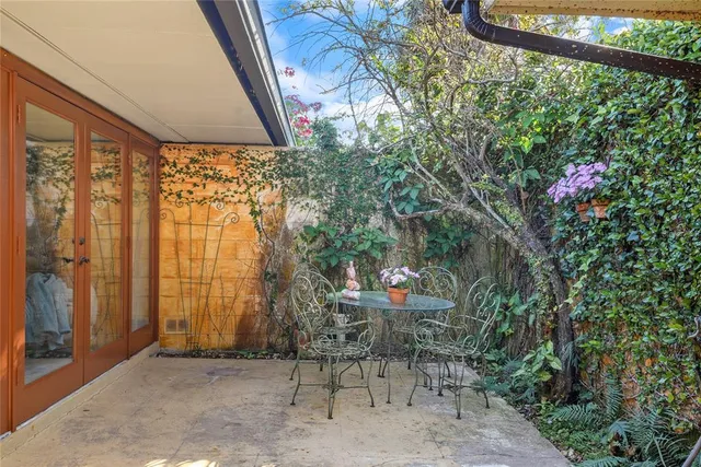a view of patio with a table and chairs and potted plants