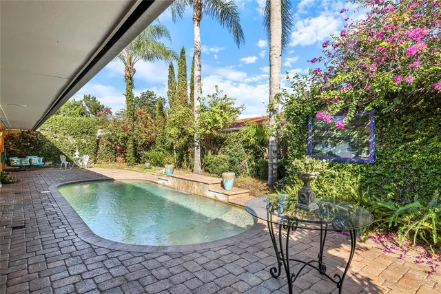 a porch with a table and chairs and potted plants