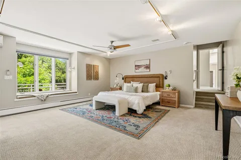 a spacious bedroom with a bed a table and chair