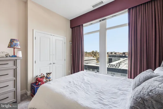 a bedroom with a bed and a large window