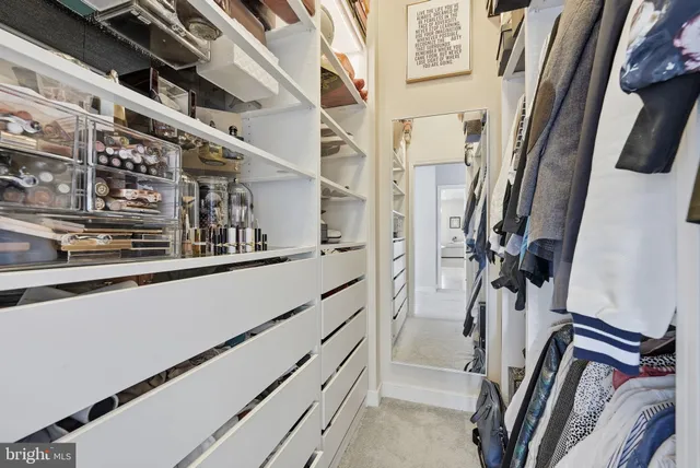 a view of walk in closet with clothes and shoes