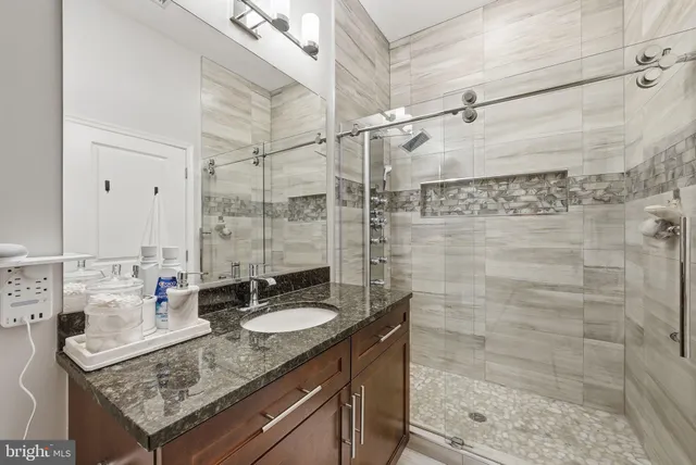 a bathroom with a sink shower and a mirror