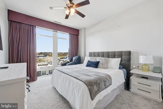 a bedroom with a bed and a large window