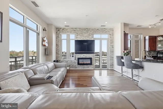 a living room with furniture a large window and a fireplace