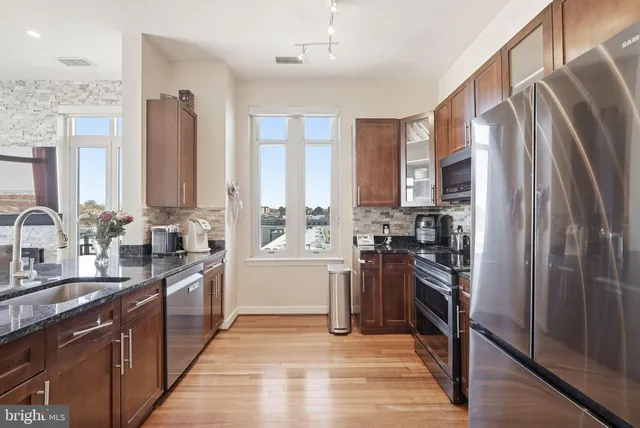 a kitchen with stainless steel appliances granite countertop a refrigerator stove and sink