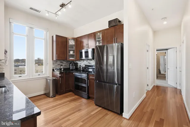 a kitchen with stainless steel appliances a refrigerator and a stove top oven