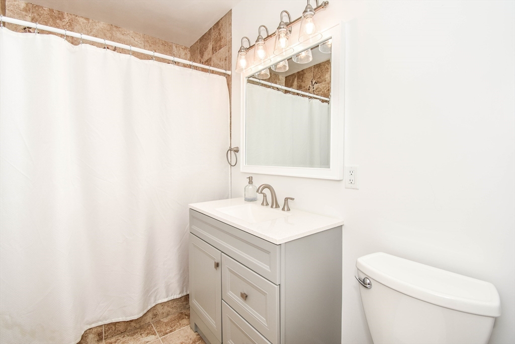 72 Evans Street, Unit 72 Watertown, MA 02472 - Photo 24 of 34 a bathroom with a toilet a sink and a mirror