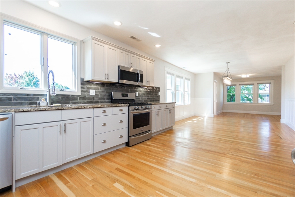 72 Evans Street, Unit 72 Watertown, MA 02472 - Photo 3 of 34 a kitchen with stainless steel appliances granite countertop a stove a sink and white cabinets