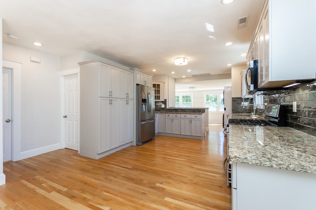72 Evans Street, Unit 72 Watertown, MA 02472 - Photo 4 of 34 a view of a kitchen with kitchen island a sink wooden floor and a refrigerator