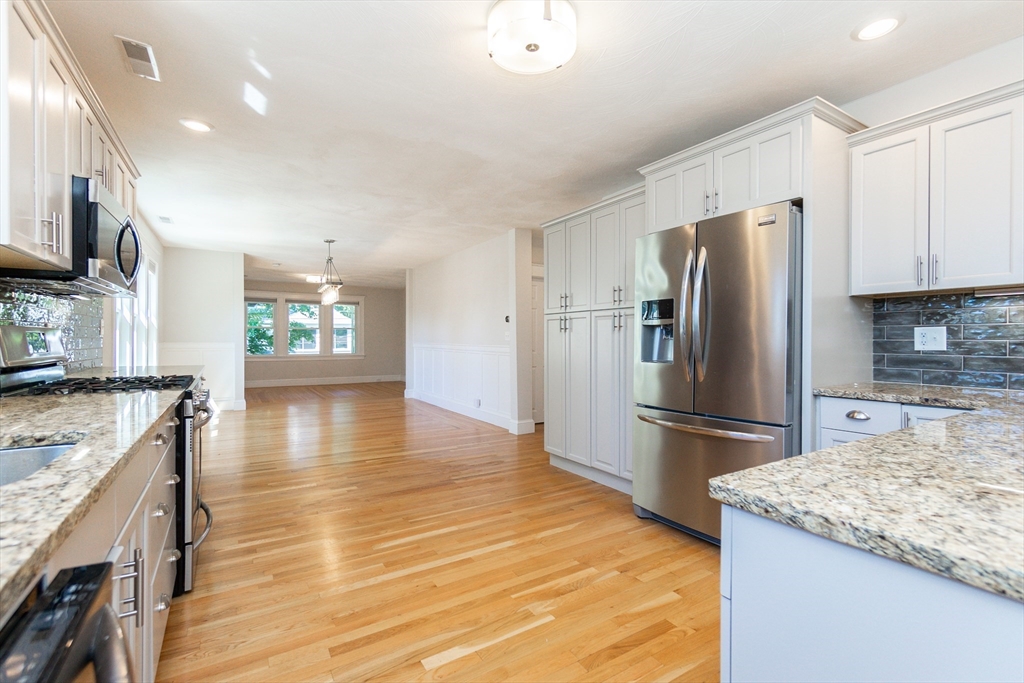 72 Evans Street, Unit 72 Watertown, MA 02472 - Photo 5 of 34 a kitchen with granite countertop a refrigerator and a stove top oven