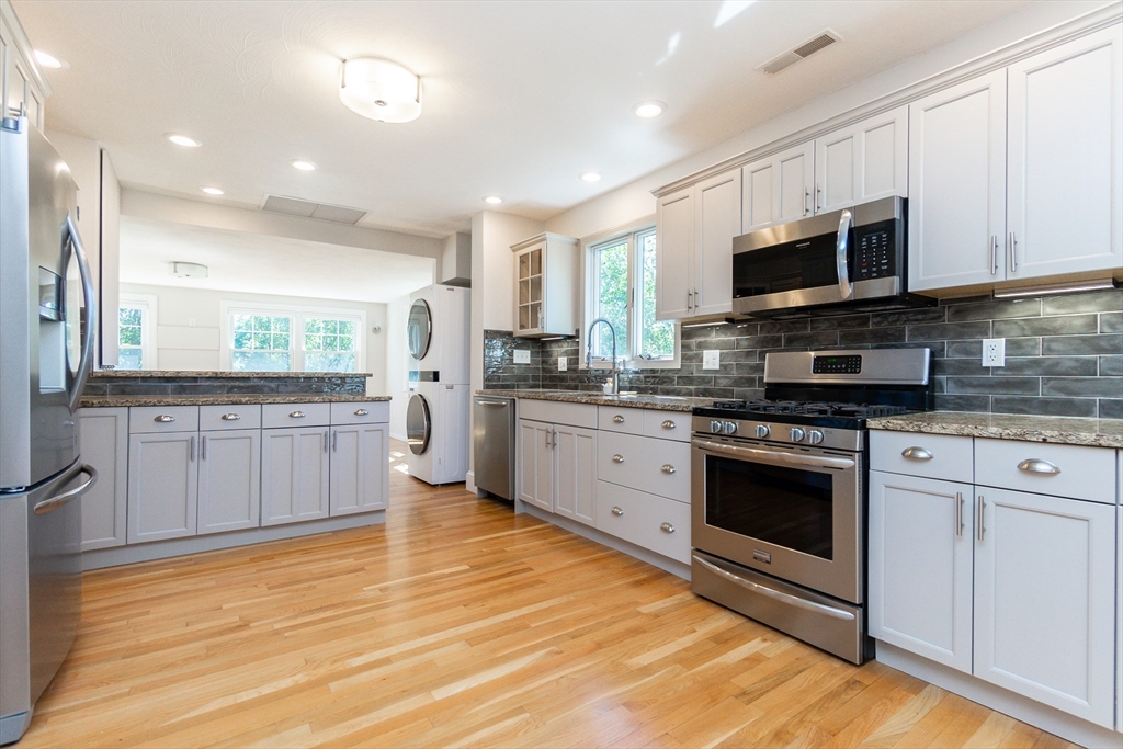 72 Evans Street, Unit 72 Watertown, MA 02472 - Photo 6 of 34 a kitchen with stainless steel appliances granite countertop a stove a sink and a microwave