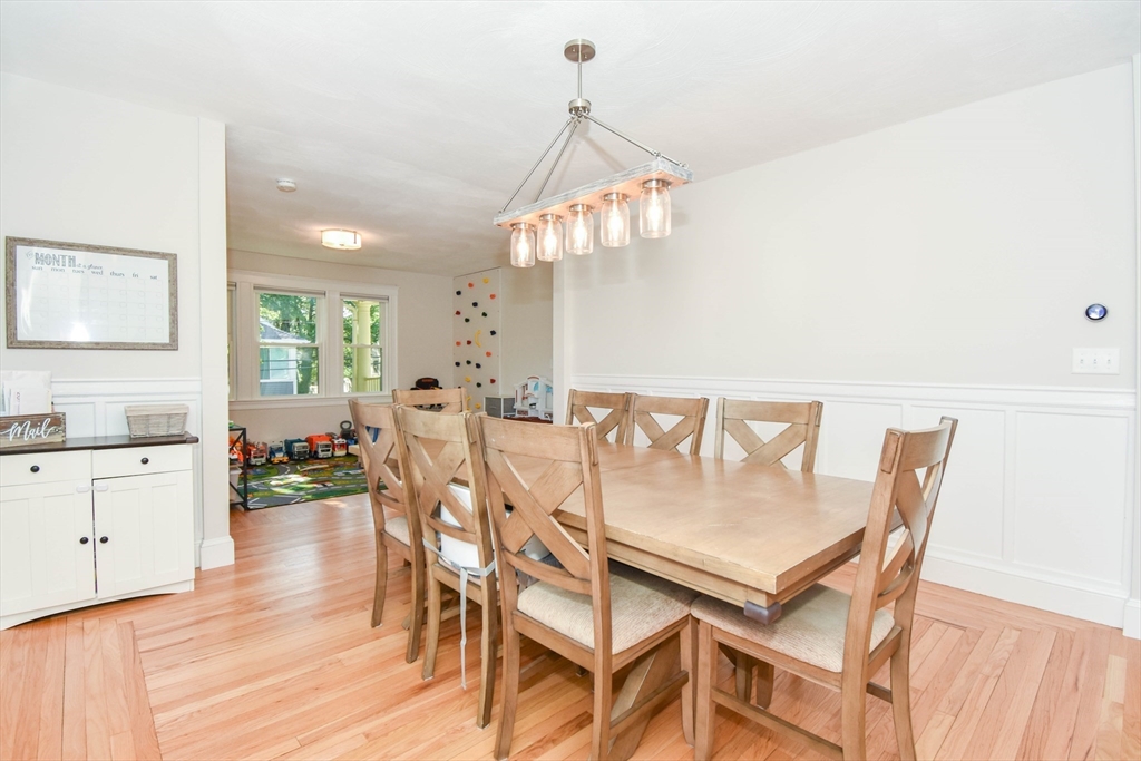 72 Evans Street, Unit 72 Watertown, MA 02472 - Photo 9 of 34 a dining room with wooden floor a chandelier a wooden table and chairs