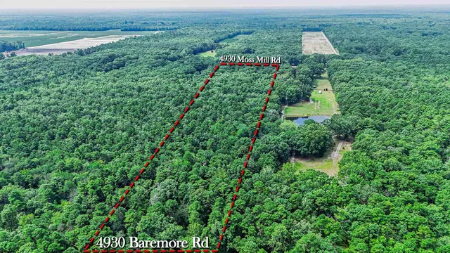 an aerial view of residential houses with outdoor space and trees