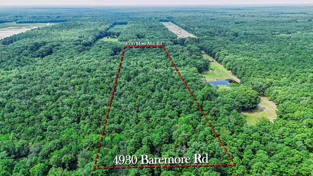 an aerial view of residential house with outdoor space and trees all around
