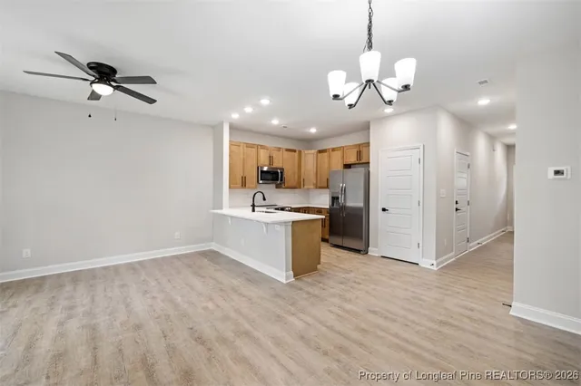 a view of a kitchen with a sink hardwood floor and a ceiling fan