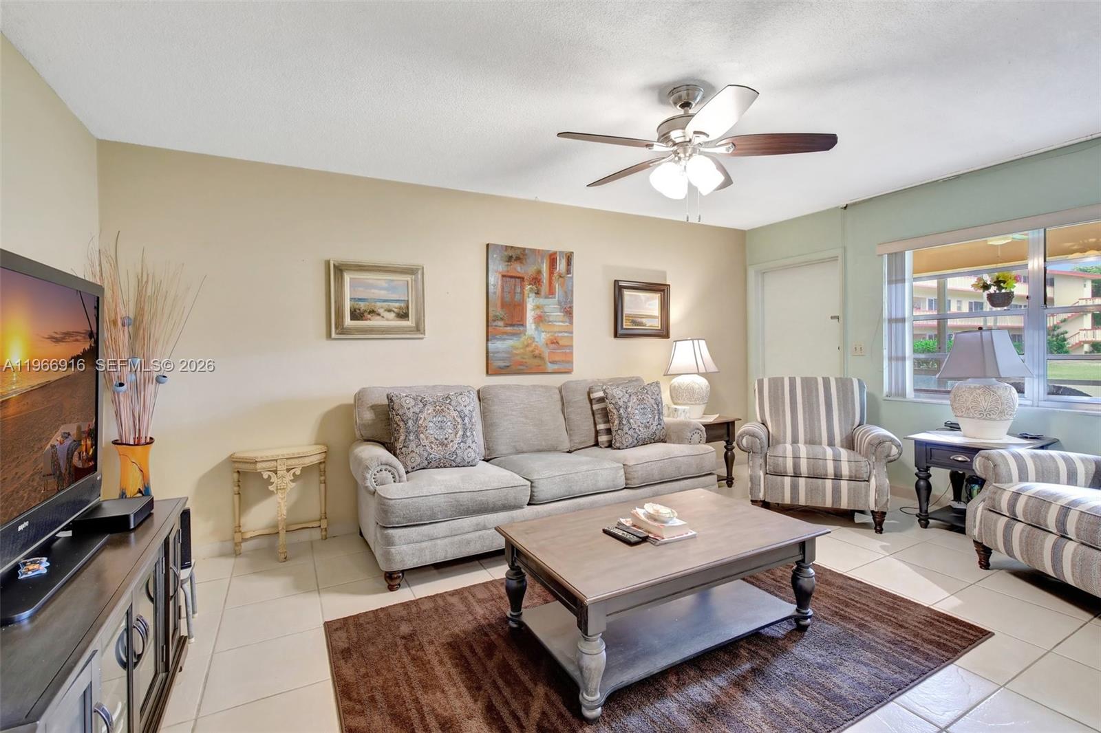 5300 Washington Street, Unit G127 Hollywood, FL 33021 - Photo 9 of 39 a living room with furniture a flat screen tv and a window