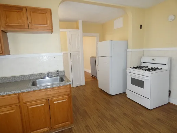 a kitchen with granite countertop a white cabinets and white appliances