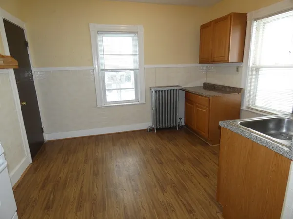 a kitchen with wooden floors and a window