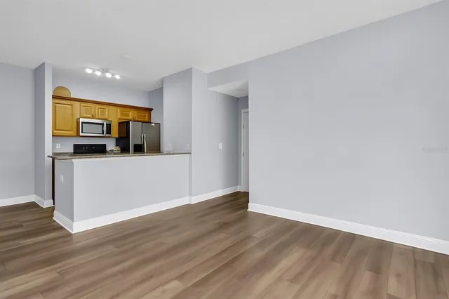 a view of a kitchen with wooden floor and electronic appliances