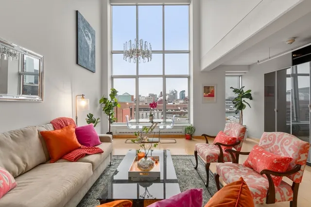 a living room with furniture fireplace and a large window