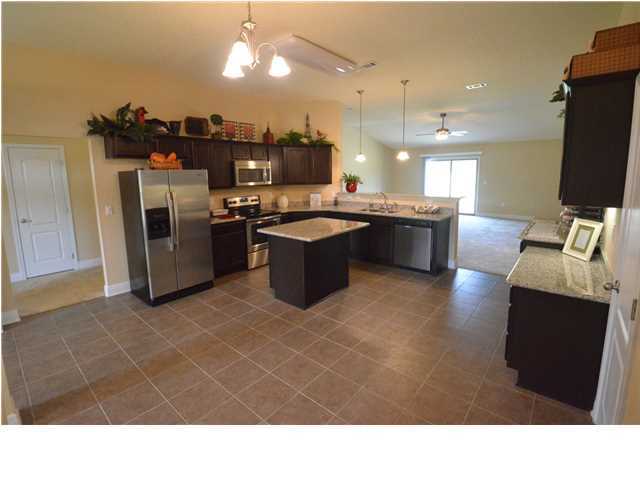 5617 Price Plantation Road Baker, FL 32531 - Photo 5 of 13 a open kitchen with a sink dishwasher and a refrigerator with wooden floor