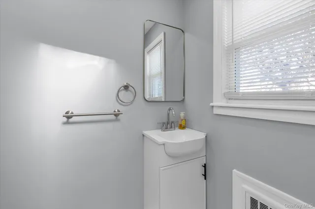 a bathroom with a sink a mirror and window