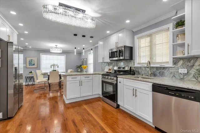 a large kitchen with cabinets chairs and a wooden floor