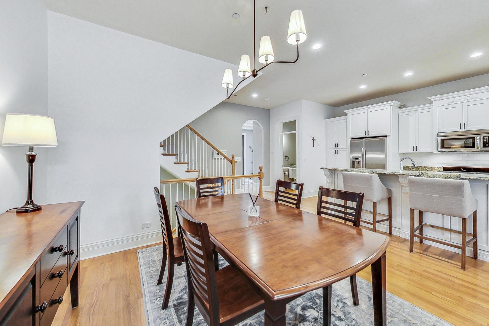 1450 East Northwest Highway, Unit 13 Arlington Heights, IL 60004 - Photo 12 of 33 an open kitchen with dining table and wooden floor
