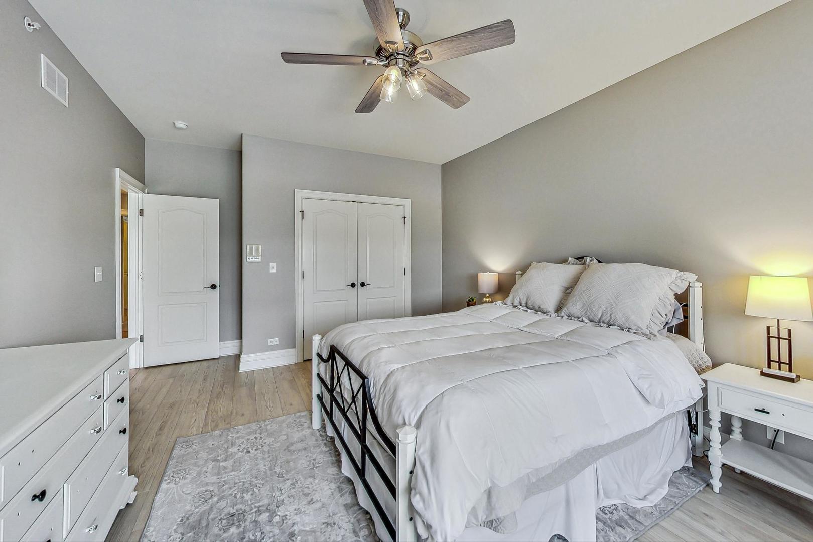 1450 East Northwest Highway, Unit 13 Arlington Heights, IL 60004 - Photo 17 of 33 a bedroom with a bed and a chandelier