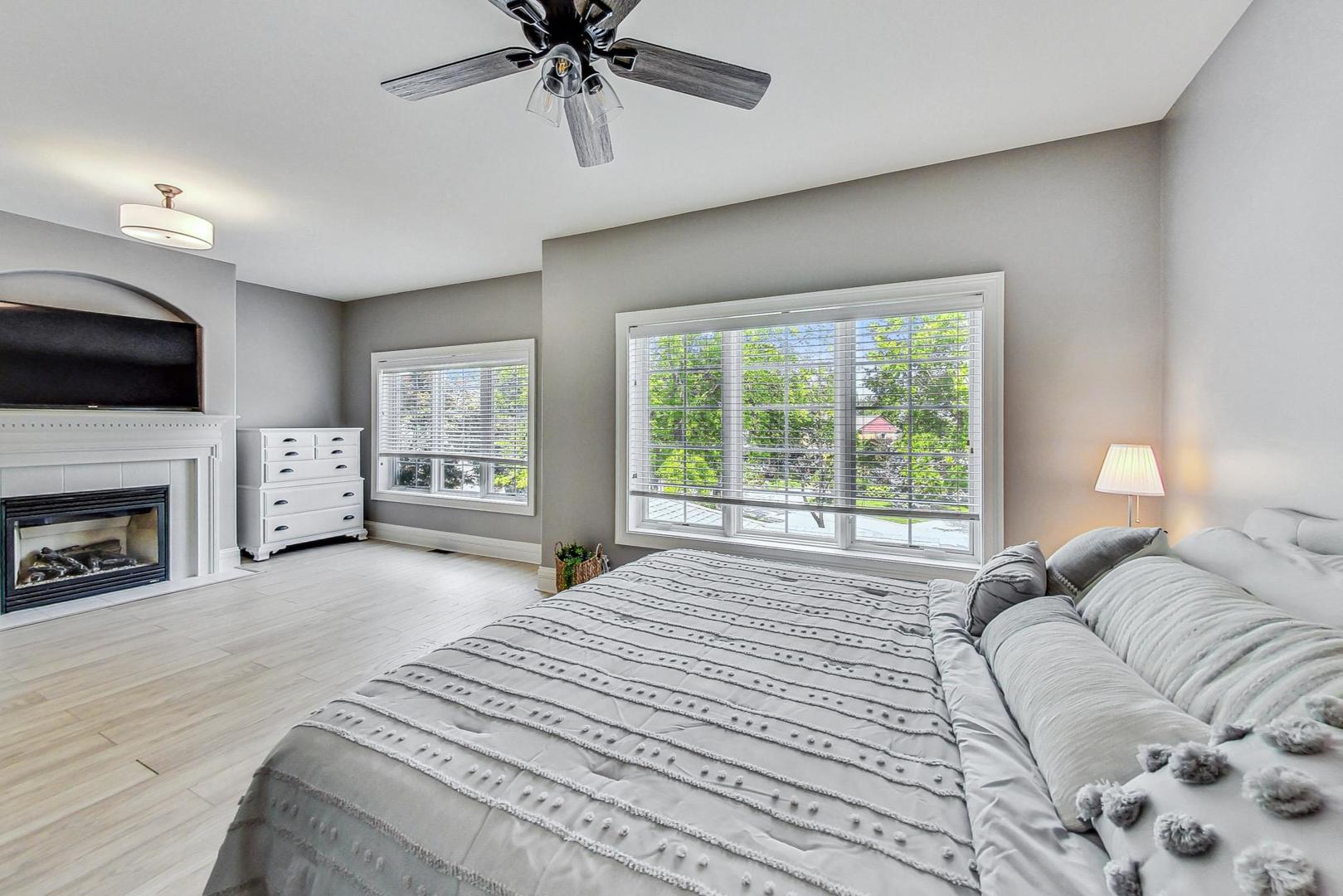 1450 East Northwest Highway, Unit 13 Arlington Heights, IL 60004 - Photo 19 of 33 a spacious bedroom with a large bed and a tv