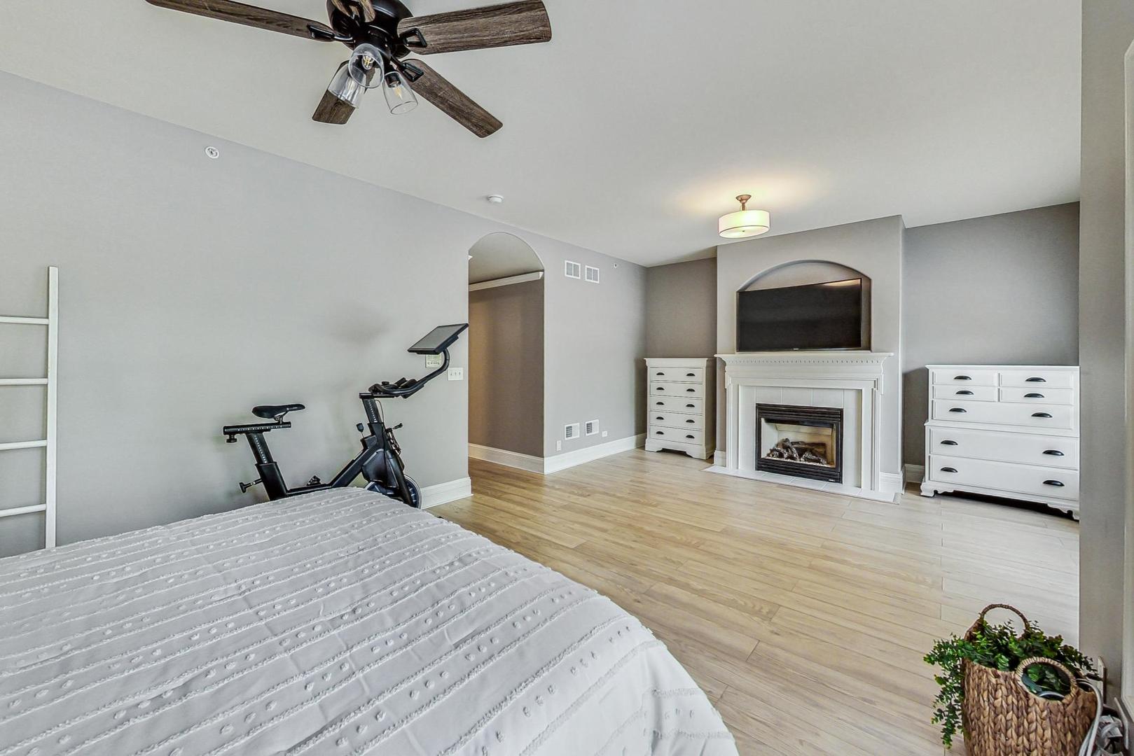 1450 East Northwest Highway, Unit 13 Arlington Heights, IL 60004 - Photo 20 of 33 a bedroom with a bed and a fireplace