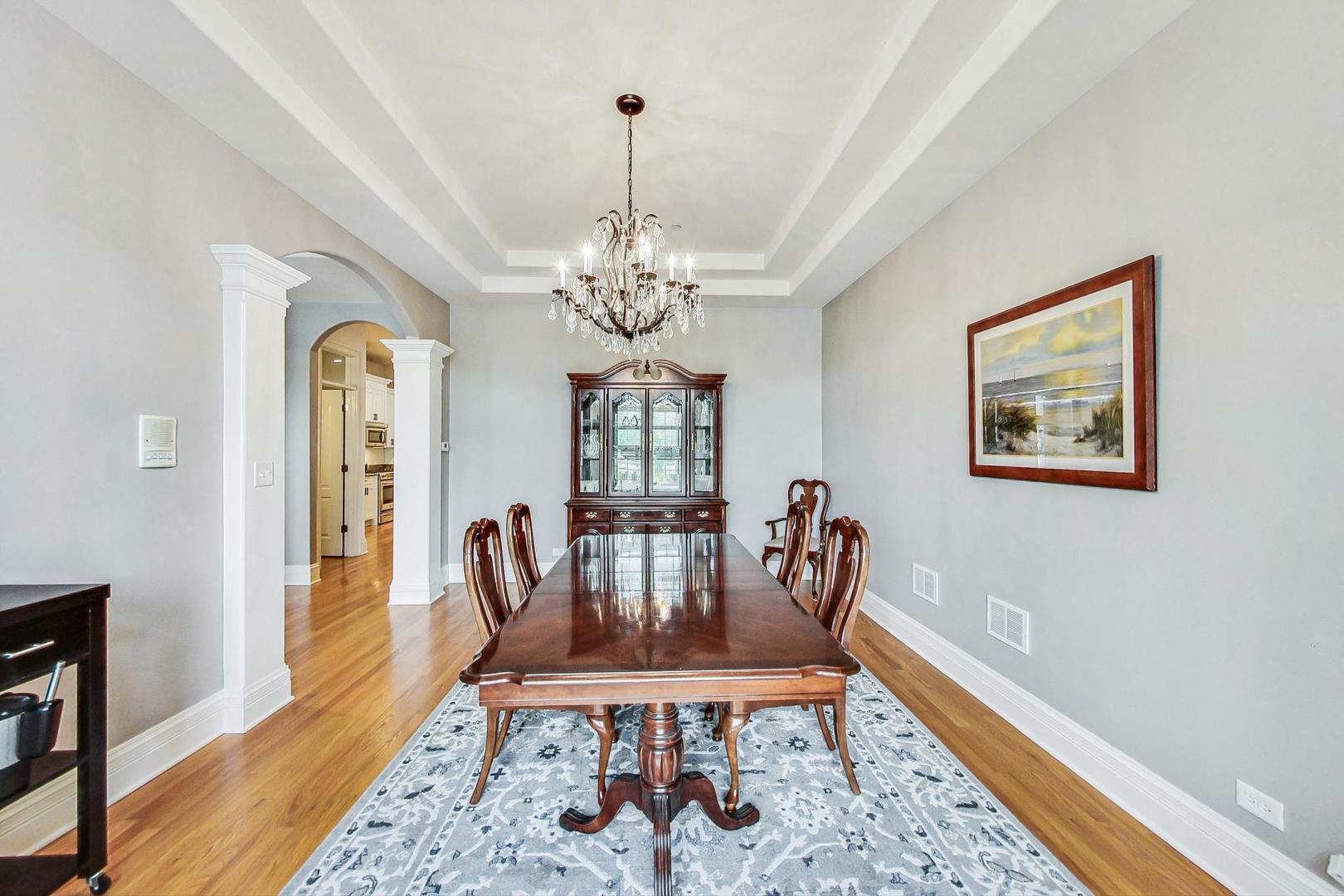 1450 East Northwest Highway, Unit 13 Arlington Heights, IL 60004 - Photo 6 of 33 a view of a dining room with furniture wooden floor and a chandelier