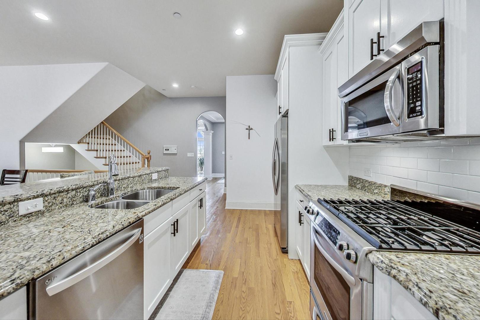 1450 East Northwest Highway, Unit 13 Arlington Heights, IL 60004 - Photo 9 of 33 a kitchen with stainless steel appliances granite countertop a sink and a stove