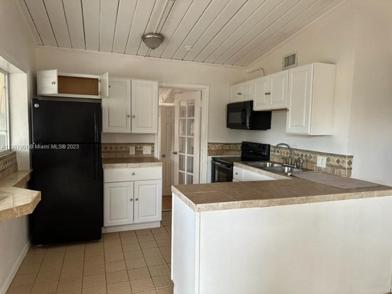 363 Glouchester Street Boca Raton, FL 33487 - Photo 5 of 13 a kitchen with a sink a stove and refrigerator