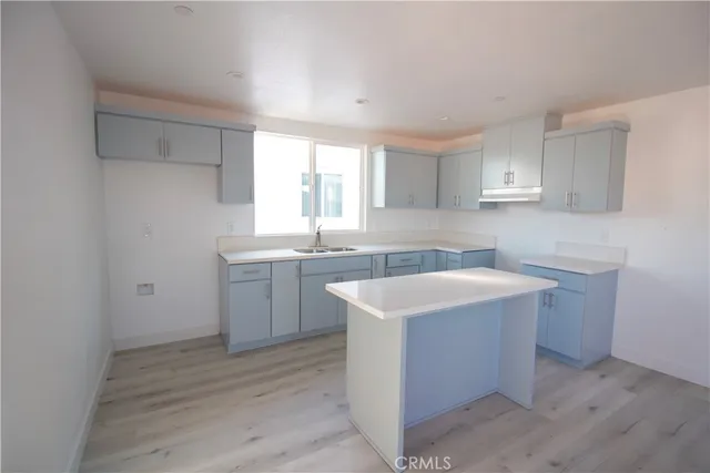 a kitchen with white cabinets sink and window