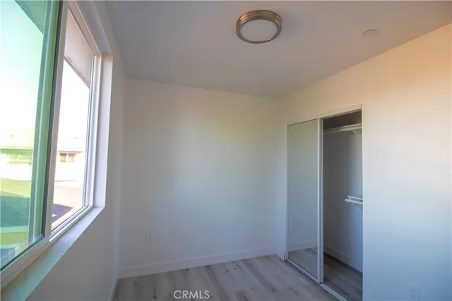 a view of a room that has wooden floor and window