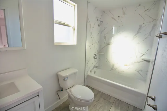 a white toilet sitting next to a bath tub