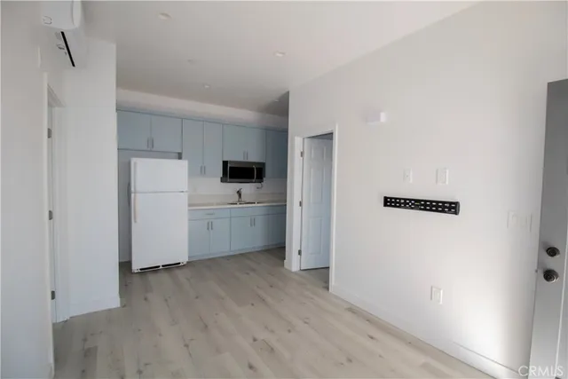 a view of a kitchen with a sink and a refrigerator