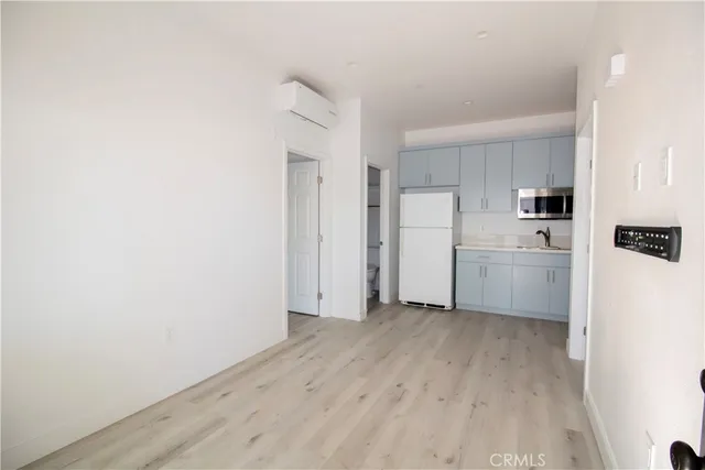 a view of a kitchen with white cabinets and wooden floor